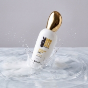 Donkey Milk and Mastic Oil Micellar Water 3 in 1 bottle splashing in fresh water with milky swirls.