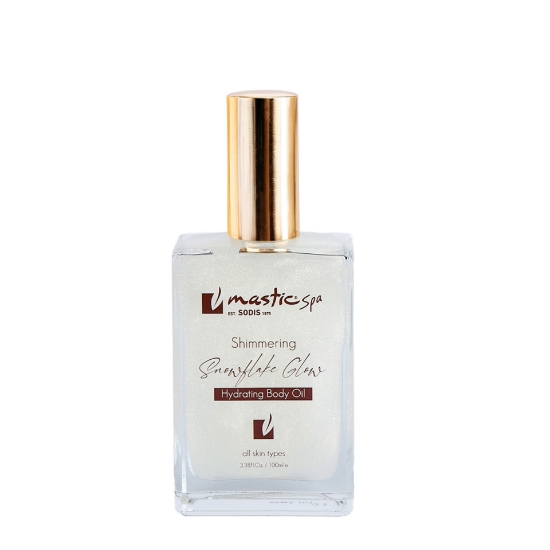Mastic Spa Shimmering Snowflake Glow Hydrating Body Oil 100ml glass bottle with a gold cap on a clean white background.
