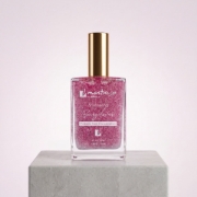 Mastic Spa Shimmering Berry Lover Body Oil bottle on stone plinth with soft pink background.