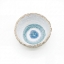 Top-down view of a handcrafted ceramic bowl with a speckled exterior and a blue concentric circle glaze inside.